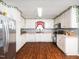 Well-lit kitchen featuring white cabinets, laminate flooring, and modern appliances for a functional cooking space at 104 Hamby Ct, Garner, NC 27529