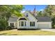 Charming white home featuring an American flag, bay window, manicured lawn, and attached garage at 105 Coral Ridge Cir, Franklinton, NC 27525