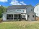 Expansive backyard view of home with manicured lawn, screened porch, and lovely landscaping at 108 Clements Dr, Morrisville, NC 27560