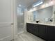 Modern bathroom with double vanity, gray cabinets, quartz countertop and a frameless glass shower at 108 Clements Dr, Morrisville, NC 27560