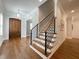 Elegant foyer with hardwood floors, staircase with metal railing, and an eye-catching pendant light at 108 Clements Dr, Morrisville, NC 27560