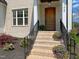 Inviting front entrance with brick steps, black iron railings and a beautiful wooden door at 108 Clements Dr, Morrisville, NC 27560