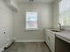 Light-filled laundry room featuring gray tile flooring, modern sink and granite countertop at 108 Clements Dr, Morrisville, NC 27560