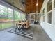 Inviting screened patio with a stone fireplace, ceiling fans, and an outdoor dining set at 108 Clements Dr, Morrisville, NC 27560