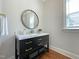 Modern powder room has a black vanity with gold accents, and a round mirror at 108 Clements Dr, Morrisville, NC 27560