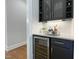 Attractive wet bar with black cabinetry, wine fridge, and marble countertops at 108 Clements Dr, Morrisville, NC 27560