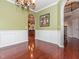 Elegant dining room with wainscoting and a chandelier, open to the kitchen at 111 Gathering Place Pl, Durham, NC 27713
