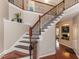 Grand foyer showcasing a staircase with wood and black metal railing, leading to the upper level of this beautiful home at 111 Gathering Place Pl, Durham, NC 27713