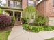 Beautiful home exterior with a brick facade, covered porch, lush landscaping, and a welcoming entrance at 111 Gathering Place Pl, Durham, NC 27713
