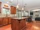 Well-lit kitchen features an island, stainless appliances, and wooden cabinetry at 111 Gathering Place Pl, Durham, NC 27713
