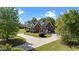 Overhead angle of a red brick home with a long driveway, lush landscaping, and a detached garage at 121 Westchase Run, Sanford, NC 27330