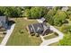 Aerial view of the brick home with a driveway and a two-car garage surrounded by lush greenery at 121 Westchase Run, Sanford, NC 27330