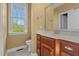 Bright bathroom features a wooden vanity with white countertop and a window view at 121 Westchase Run, Sanford, NC 27330