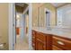 Bathroom featuring a vanity with cabinets, a large mirror, and a hallway entrance at 121 Westchase Run, Sanford, NC 27330