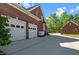 Spacious three-car garage in a beautiful brick home with an extensive concrete driveway and lush green trees at 121 Westchase Run, Sanford, NC 27330
