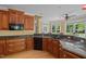 Kitchen with granite countertops, cherry cabinets, modern appliances, and bay window overlooking the backyard at 121 Westchase Run, Sanford, NC 27330