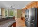 Bright kitchen area with granite countertops, wooden cabinets, a refrigerator, desk, and bay windows at 121 Westchase Run, Sanford, NC 27330