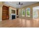 Spacious living room with hardwood floors, a fireplace, built-in shelves, and three large windows at 121 Westchase Run, Sanford, NC 27330