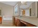 A well-lit bathroom with a tub, vanity with cabinets, and a large mirror at 121 Westchase Run, Sanford, NC 27330