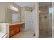 Well-lit bathroom features a vanity with cabinets, a large mirror and a glass-enclosed shower at 121 Westchase Run, Sanford, NC 27330