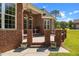 Charming covered patio with brick accents and decorative details, perfect for relaxing in a serene outdoor setting at 121 Westchase Run, Sanford, NC 27330