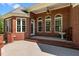 Charming covered patio with brick accents, a ceiling fan, and a decorative bird bath in a serene outdoor space at 121 Westchase Run, Sanford, NC 27330