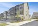 Modern gray townhome featuring a two car garage, gray siding, and a well manicured lawn at 1215 Corkery Ridge Ct, Cary, NC 27519
