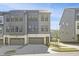 Modern gray townhome featuring a two car garage, gray siding, and a well manicured lawn at 1215 Corkery Ridge Ct, Cary, NC 27519