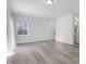Minimalist living room featuring hardwood floors, neutral walls, a large window and a view of a bathroom at 1215 Corkery Ridge Ct, Cary, NC 27519