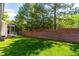 Well-maintained backyard with lush green grass and a brick wall, offering privacy and space at 12308 Bunchgrass Ln, Raleigh, NC 27614