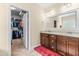 Dual sink bathroom with granite counters and walk-in closet access at 12308 Bunchgrass Ln, Raleigh, NC 27614