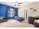 Bright bedroom featuring a twin bed, blue accent wall, and a ceiling fan at 12308 Bunchgrass Ln, Raleigh, NC 27614