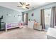 Cozy bedroom with a ceiling fan, large windows, and soft blue walls at 12308 Bunchgrass Ln, Raleigh, NC 27614