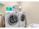 Functional laundry room with a washer and dryer, shelving, and ample space for organization at 12308 Bunchgrass Ln, Raleigh, NC 27614