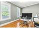 Bright home office with hardwood floors, large windows, and modern desk setup at 12308 Bunchgrass Ln, Raleigh, NC 27614