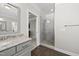 Bright bathroom featuring a glass-enclosed shower, granite counter, and gray cabinets at 1305 Reservoir View Ln, Wake Forest, NC 27587