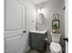 Well-lit bathroom with a modern vanity, round mirror, toilet, and stylish decor at 1305 Reservoir View Ln, Wake Forest, NC 27587
