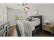 Cozy bedroom featuring a bed with neutral bedding, wood floors, and a dresser for storage at 1305 Reservoir View Ln, Wake Forest, NC 27587