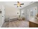 Bright Bedroom features floral wallpaper, white crib, ceiling fan, and plaid glider with natural lighting and wood floors at 1305 Reservoir View Ln, Wake Forest, NC 27587