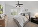 Cozy bedroom features a ceiling fan, neutral walls, a large window, and comfortable bedding at 1305 Reservoir View Ln, Wake Forest, NC 27587