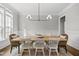 Bright dining room featuring a wood table, stylish light fixture, and decoratively woven chairs at 1305 Reservoir View Ln, Wake Forest, NC 27587