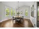 Dining room features a modern chandelier, wood table, and multiple windows with natural light at 1305 Reservoir View Ln, Wake Forest, NC 27587