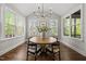 Bright dining area features many windows, chandelier, wood table, and seating for four at 1305 Reservoir View Ln, Wake Forest, NC 27587