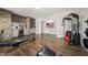 Finished basement with exposed brick wall has full gym with workout equipment and hard wood flooring at 1305 Reservoir View Ln, Wake Forest, NC 27587
