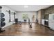 This home gym features hard wood flooring, exercise equipment and natural light at 1305 Reservoir View Ln, Wake Forest, NC 27587