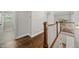 Second story hallway features hardwood floors, wood and white banister, and access to other rooms at 1305 Reservoir View Ln, Wake Forest, NC 27587