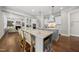 Open concept kitchen features a long island, bar stool seating, custom cabinets, and stainless steel appliances at 1305 Reservoir View Ln, Wake Forest, NC 27587