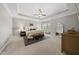 Spacious main bedroom suite with tray ceiling, ceiling fan, sitting area, and large windows at 1305 Reservoir View Ln, Wake Forest, NC 27587