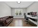 Well-lit office with hardwood floors, a brown leather couch, a modern desk, and a large window at 1305 Reservoir View Ln, Wake Forest, NC 27587