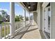 This covered porch features white columns, ceiling fan, wood flooring, and an outdoor view at 1305 Reservoir View Ln, Wake Forest, NC 27587